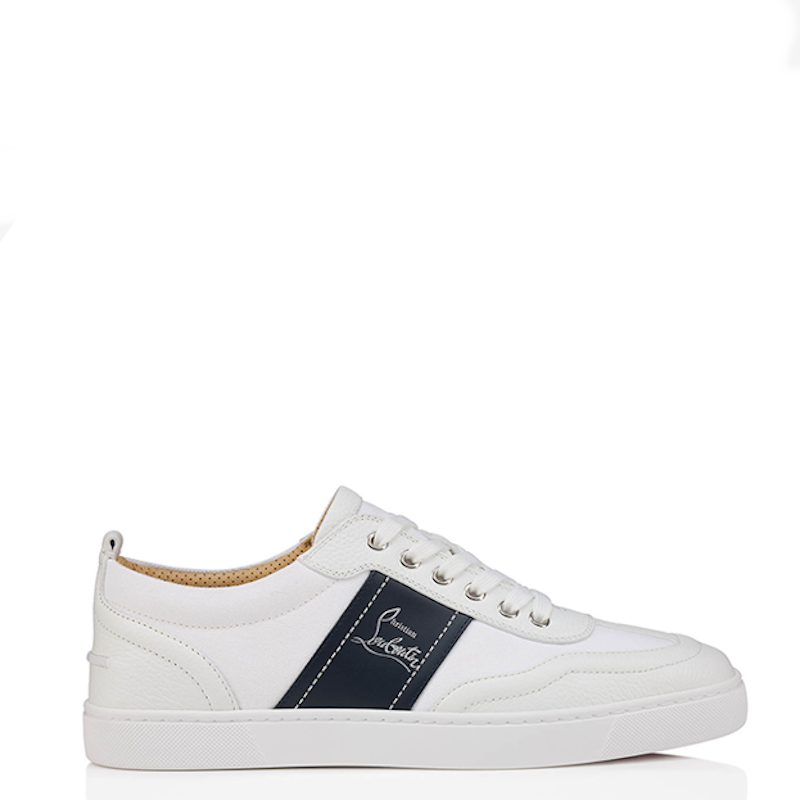A white leather low-top sneaker with a navy blue side stripe featuring a white embroidered logo, shown from the side on a white background.