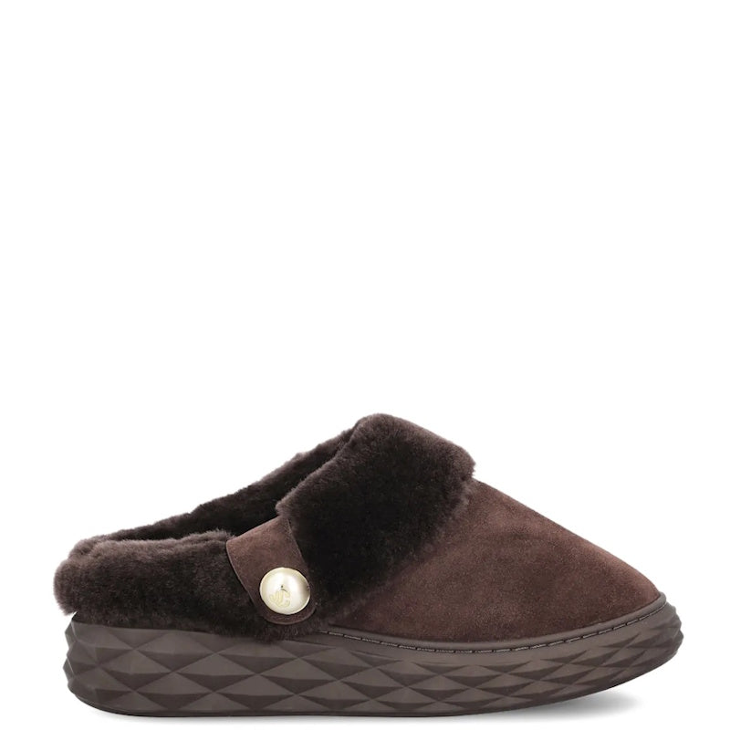 A dark brown slip-on clog slipper featuring a plush dark brown faux-fur collar, a matching brown suede upper, a decorative button detail, and a textured geometric sole.