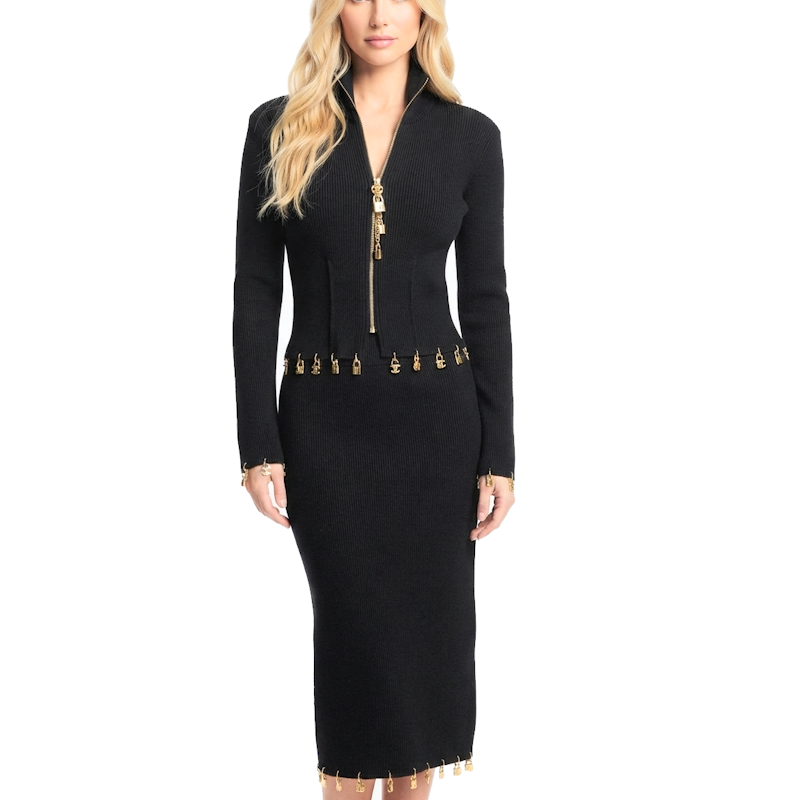 A woman modeling a black long-sleeve knit midi dress with a front zipper, gold-tone decorative hardware at the waist, and gold fringe trim at the hem, set against a plain white background.