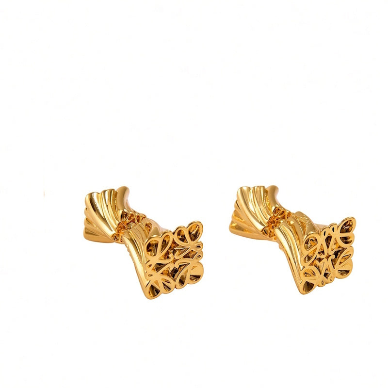 A pair of gold-toned cufflinks with an intricate, textured scrollwork design and leaf-like flared ends, shown on a plain white background.