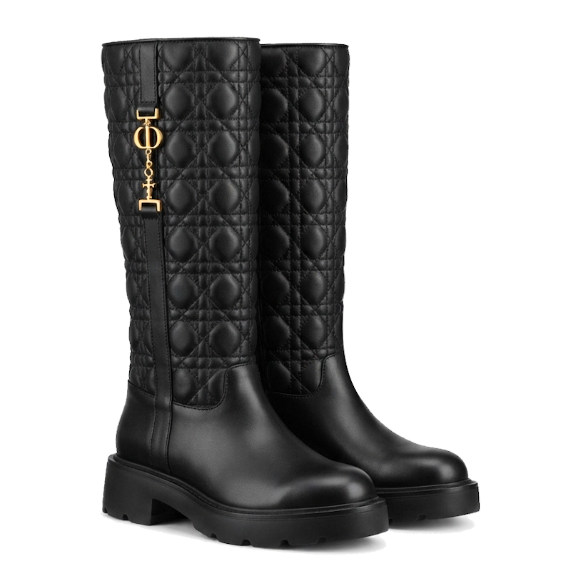 A pair of black quilted leather knee-high boots with a gold-tone logo charm on the side, set against a plain white background.