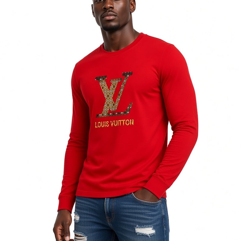 A man wearing a bright red long-sleeve crewneck shirt with a large Louis Vuitton  logo in gold and black on the chest, paired with distressed blue jeans, against a plain white background.